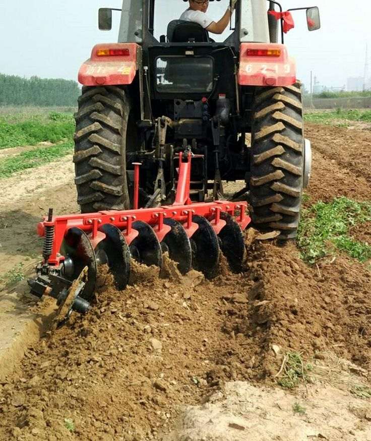 Tractor with disc plough preparing farmland